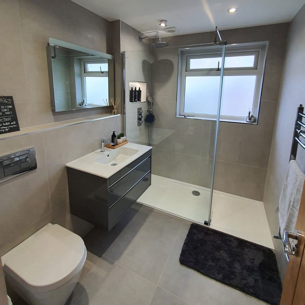 Bathroom with a dark vanity unit and a corner shower enclosure