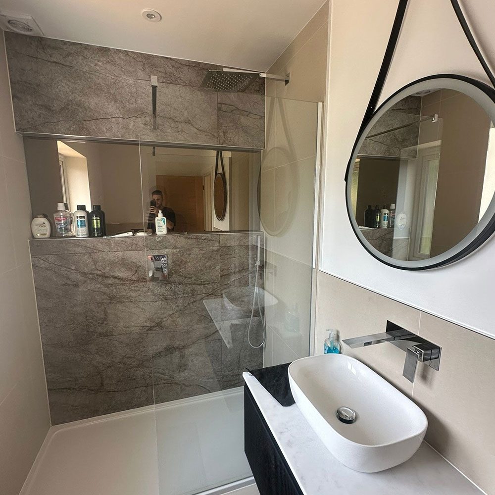 Bathroom with stone tiling and a backlit mirror