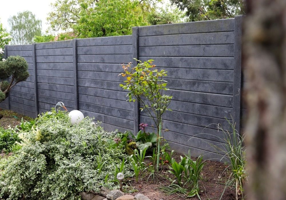 Dark grey composite fencing with a planted border