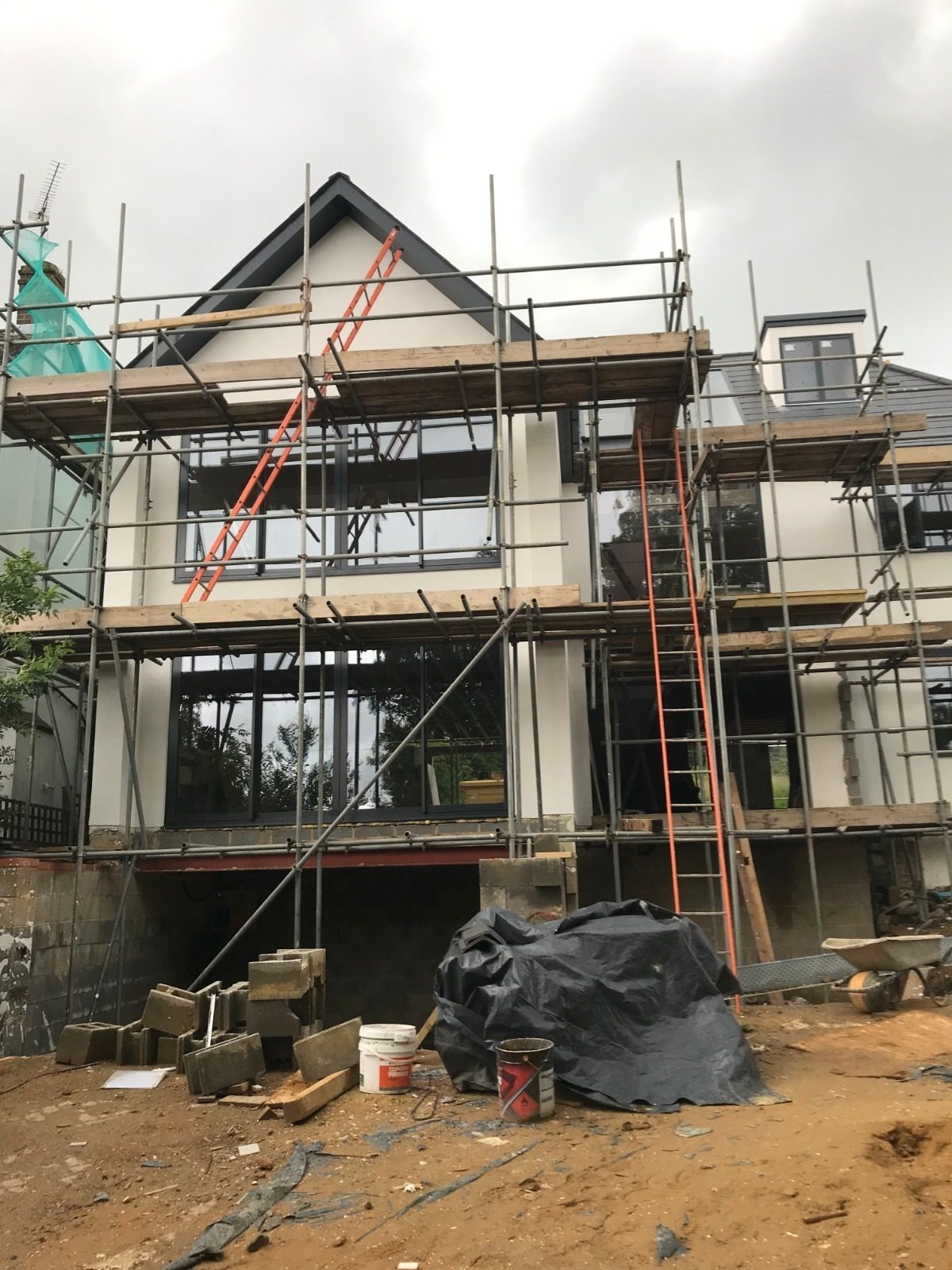 Detached house under construction with scaffolding and a new roof structure