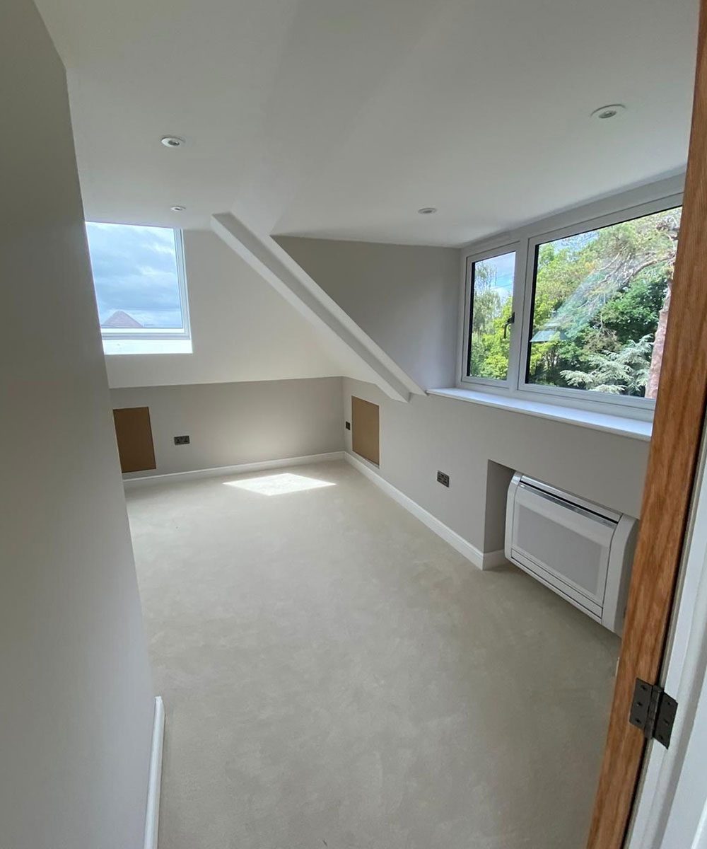 Finished loft conversion with a roof window and clean plaster lines