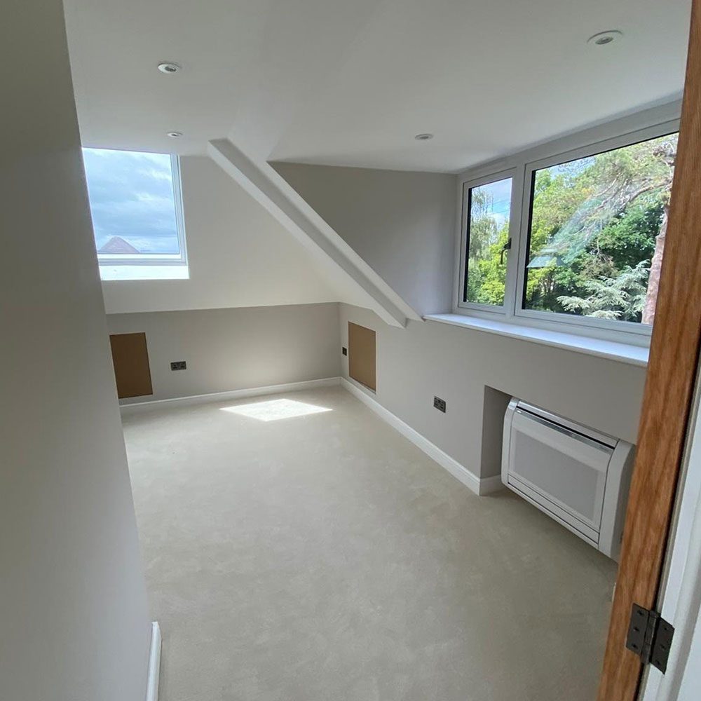Finished loft conversion with a Velux roof window and plastered walls