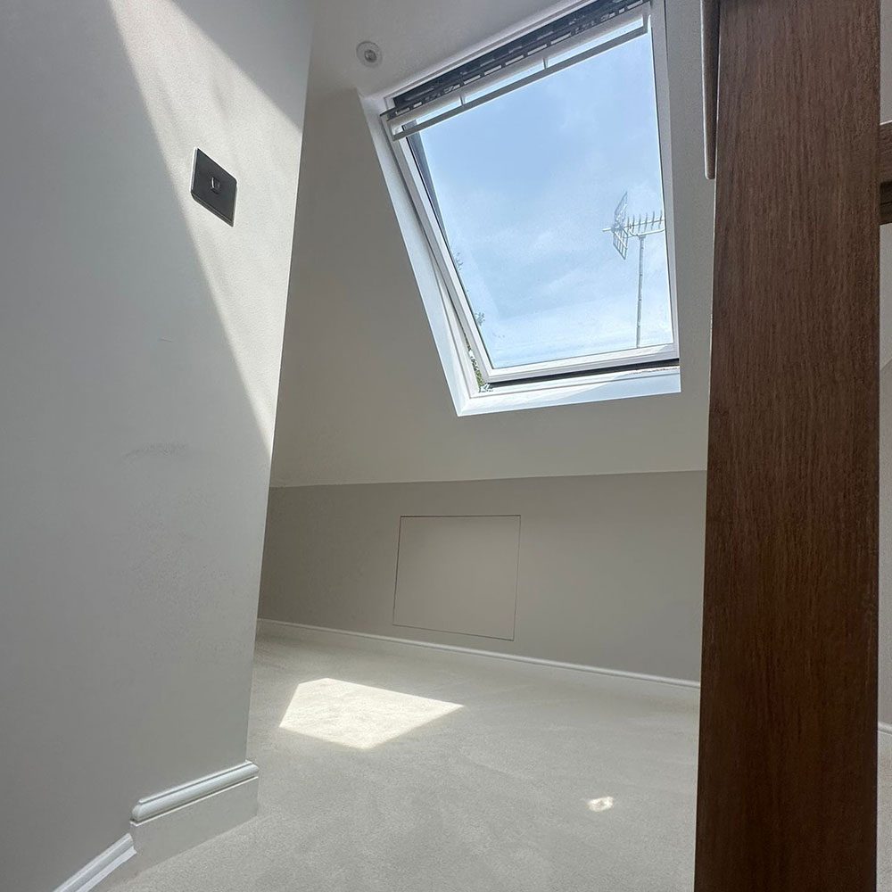 Completed loft room with a roof window and radiator